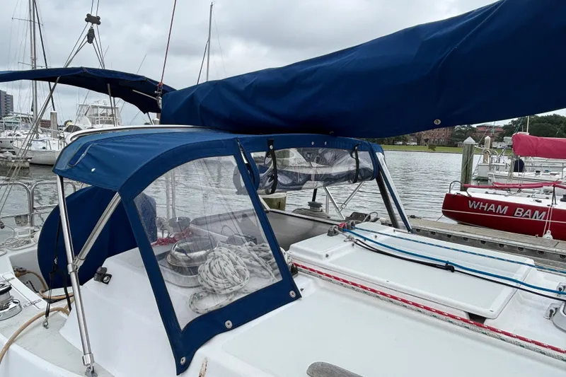 Slide: The Image of 1988 J Boats J/28 sailboat with blue canvas cover docked at marina. - 10