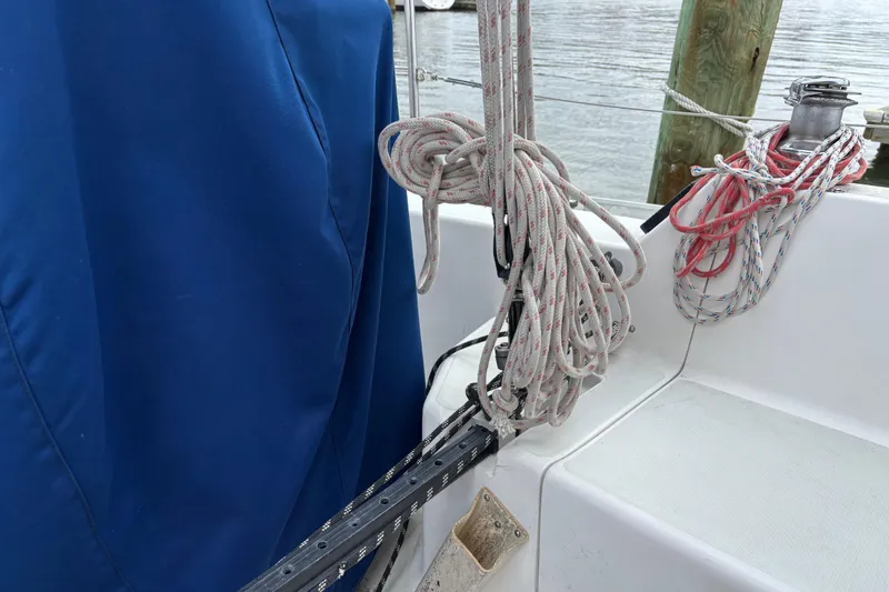 Slide: The Image of Ropes and winch on 1988 J Boats J/28 sailboat deck, docked by water. - 11