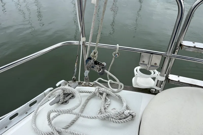 Slide: The Image of 1988 J Boats J/28 sailboat deck with ropes and railing by the water. - 20