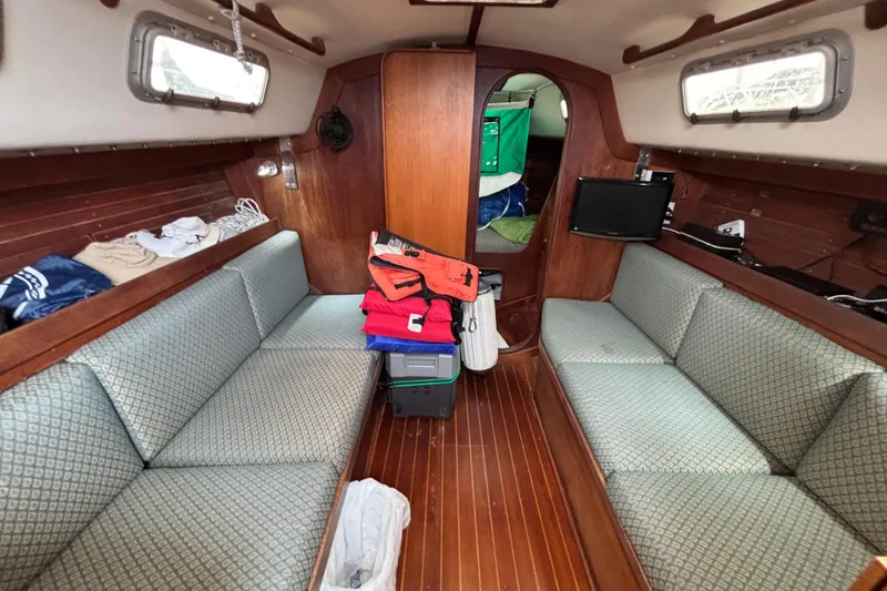 Slide: The Image of Interior of a 1988 J Boats J/28 sailboat with cozy seating and wooden finishes. - 22