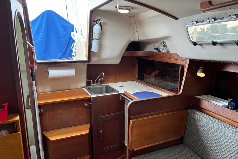 Slide: The Image of Interior of a 1988 J Boats J/28 sailboat featuring a compact kitchen area. - 23