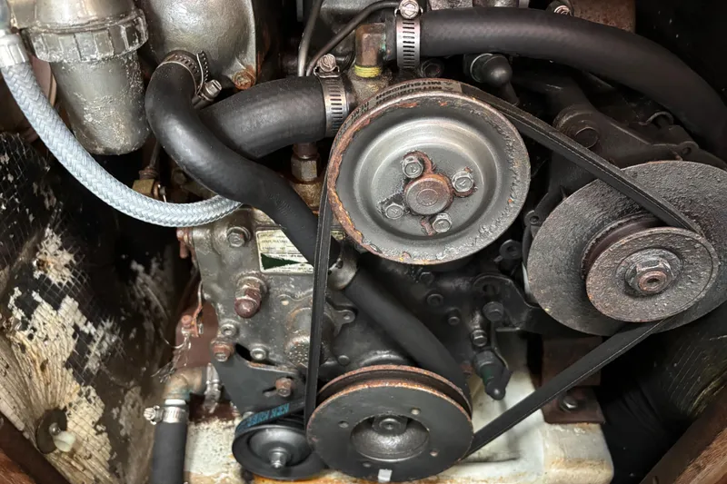 Slide: The Image of Engine components of a 1988 J Boats J/28, featuring belts and hoses. - 32