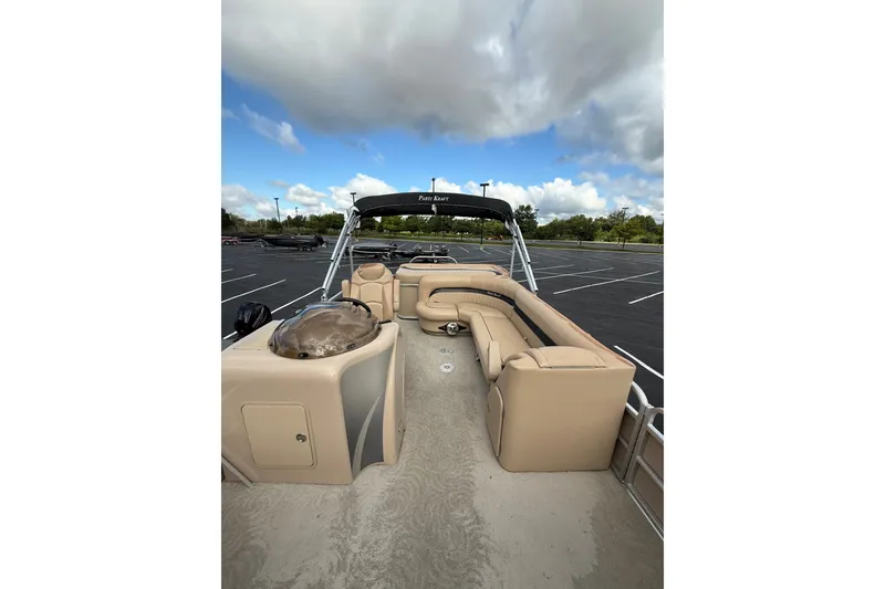Slide: The Image of 2008 Parti Kraft 240RE pontoon boat with beige seating, parked under a cloudy sky. - 3