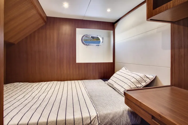 Slide: The Image of Luxurious cabin interior of 2026 Selene 92 Ocean Explorer yacht with wood paneling and striped bedding. - 18