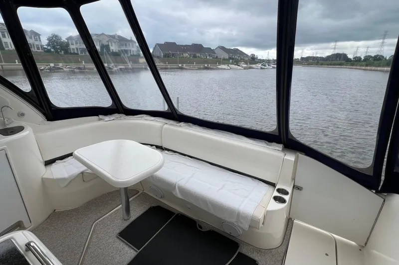 Slide: The Image of 2005 Cruisers Yachts 400 Express interior with waterfront view, featuring seating and table. - 13