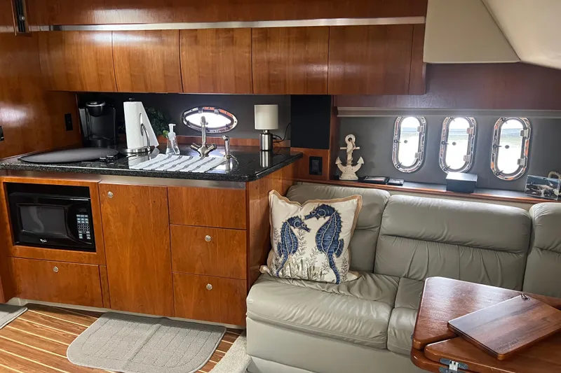 Slide: The Image of Interior of 2005 Cruisers Yachts 400 Express with kitchenette and leather seating. - 20