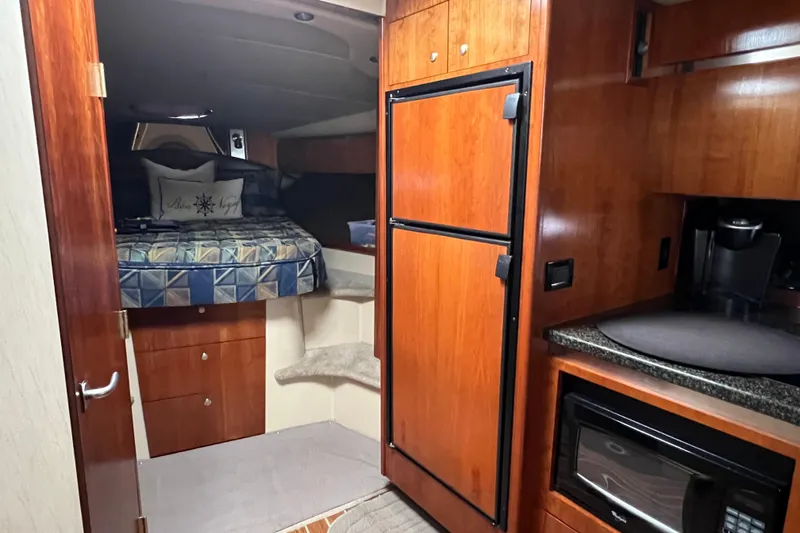 Slide: The Image of 2005 Cruisers Yachts 400 Express interior with kitchenette and cozy sleeping area. - 25