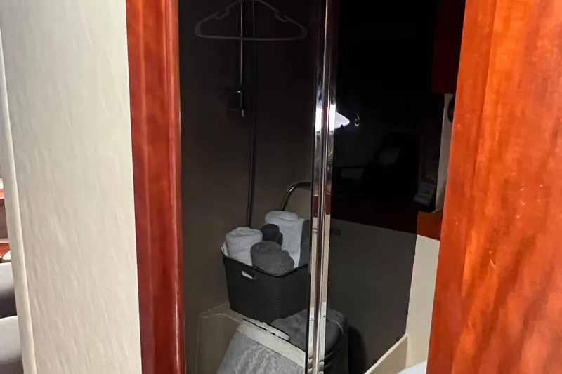 Slide: The Image of Interior of 2005 Cruisers Yachts 400 Express, featuring a compact bathroom with towels. - 28