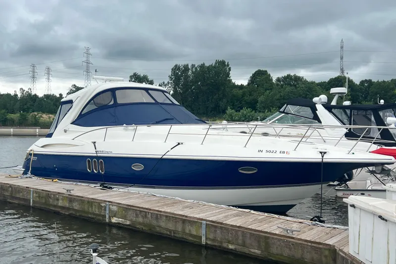 Slide: The Image of 2005 Cruisers Yachts 400 Express docked, featuring sleek design and blue accents. - 6