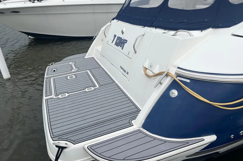 Slide: The Image of 2005 Cruisers Yachts 400 Express docked, featuring a sleek swim platform and blue hull. - 9