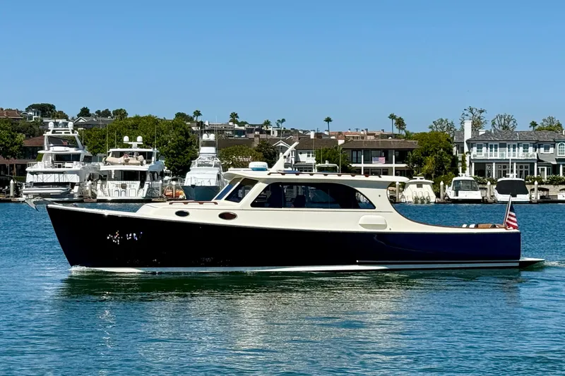 Slide: The Image of 2002 Palm Beach Motor Yachts Avalon 38 cruising on a sunny day near a marina. - 29