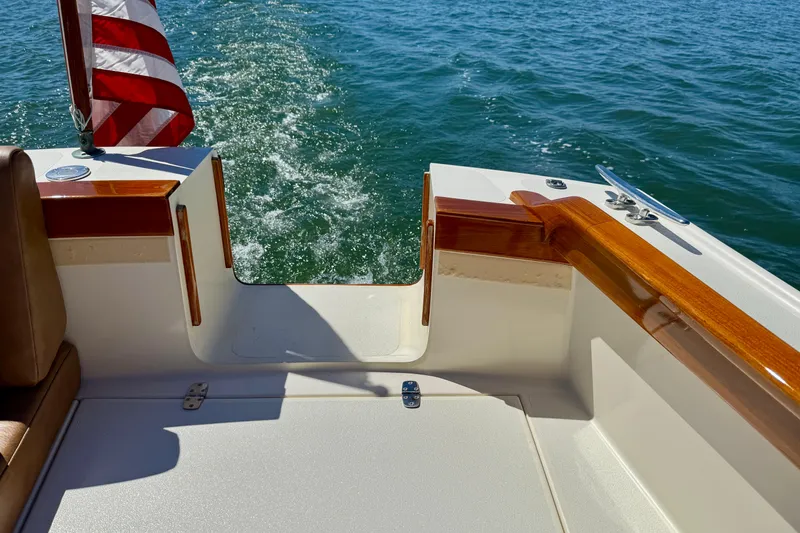 Slide: The Image of 2002 Palm Beach Motor Yachts Avalon 38, rear view with American flag, cruising on water. - 35