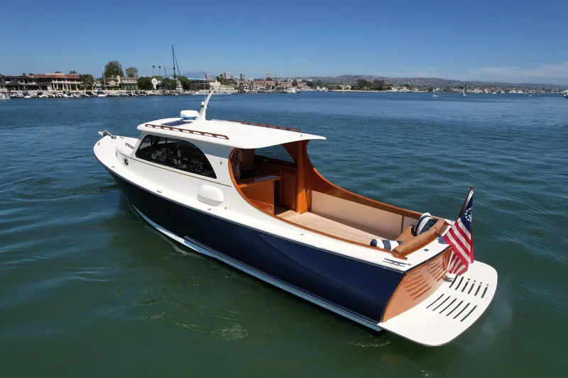 Slide: The Image of 2002 Palm Beach Motor Yachts Avalon 38 cruising on calm waters, featuring elegant design and American flag. - 5