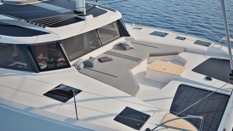Slide: The Image of 2026 Fountaine Pajot 44 catamaran deck with cushions and table, sailing on calm waters. - 8