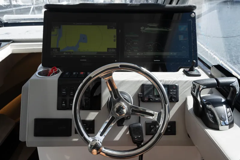 Slide: The Image of Helm of 2022 Regal 36 XO boat with dual navigation screens and steering wheel. - 21