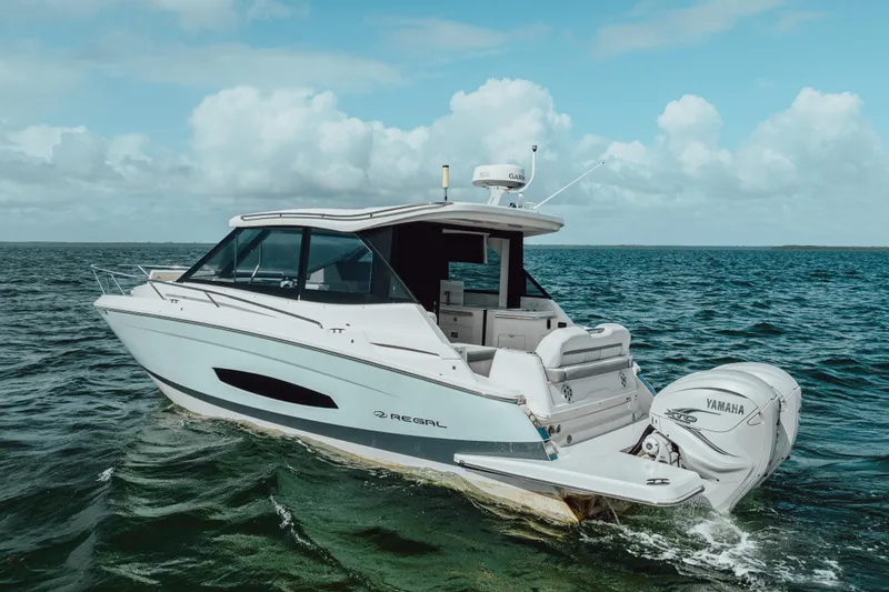 Slide: The Image of 2022 Regal 36 XO boat cruising on open water under a cloudy sky. - 7