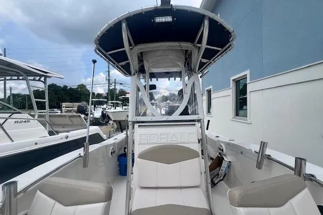 Slide: The Image of 2017 Robalo R200 Center Console boat with seating, docked near a blue building. - 15