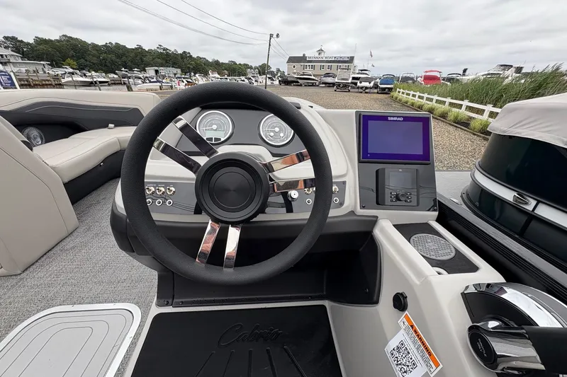 Slide: The Image of 2026 Barletta C22UC boat dashboard with steering wheel and navigation display. - 14