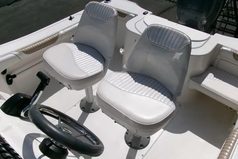 Slide: The Image of 2005 Seaswirl 1851 CC O/B boat interior with dual white seats and steering wheel. - 18