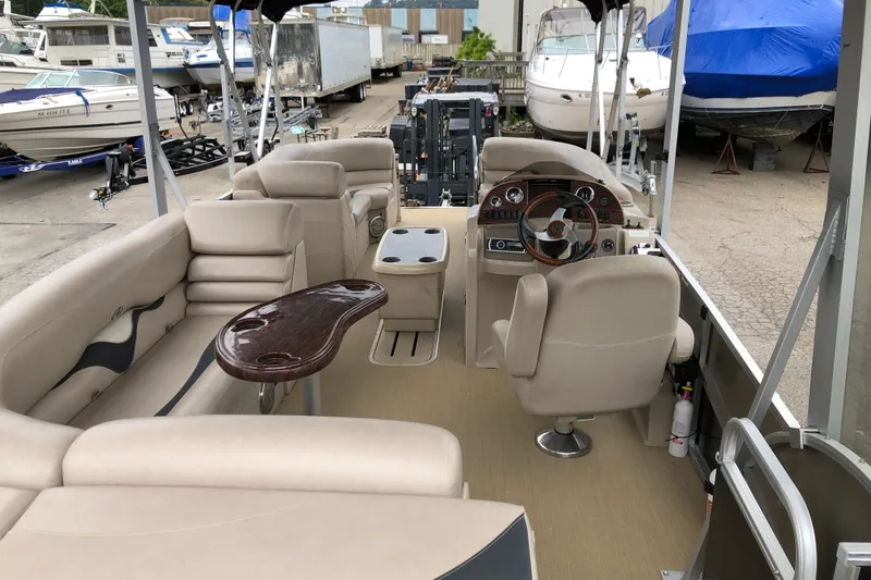 Slide: The Image of 2013 Avalon FUNSHIP 2485 pontoon boat interior with beige seating and wooden accents. - 10