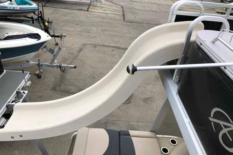 Slide: The Image of 2013 Avalon FUNSHIP 2485 boat with a slide, parked on a trailer. - 12