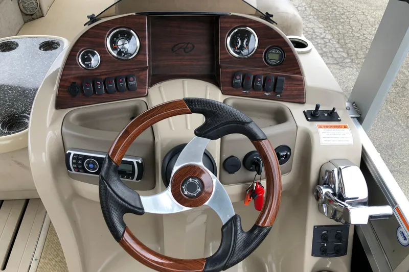 Slide: The Image of Steering console of 2013 Avalon FUNSHIP 2485 boat with wood accents and gauges. - 7