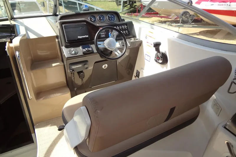Slide: The Image of 2017 Sea Ray Sundancer 280 cockpit with steering wheel and navigation controls. - 17