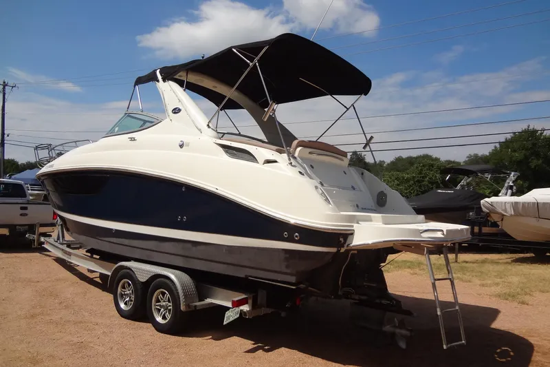 Slide: The Image of 2017 Sea Ray Sundancer 280 boat on trailer, parked outdoors under a clear sky. - 2