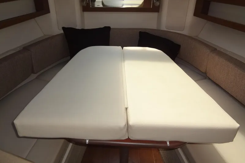 Slide: The Image of 2017 Sea Ray Sundancer 280 cabin interior with convertible seating and cushions. - 30