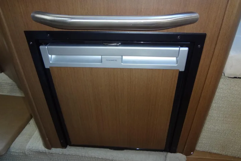 Slide: The Image of 2017 Sea Ray Sundancer 280 interior with Dometic fridge, wooden paneling, and stainless steel handle. - 34