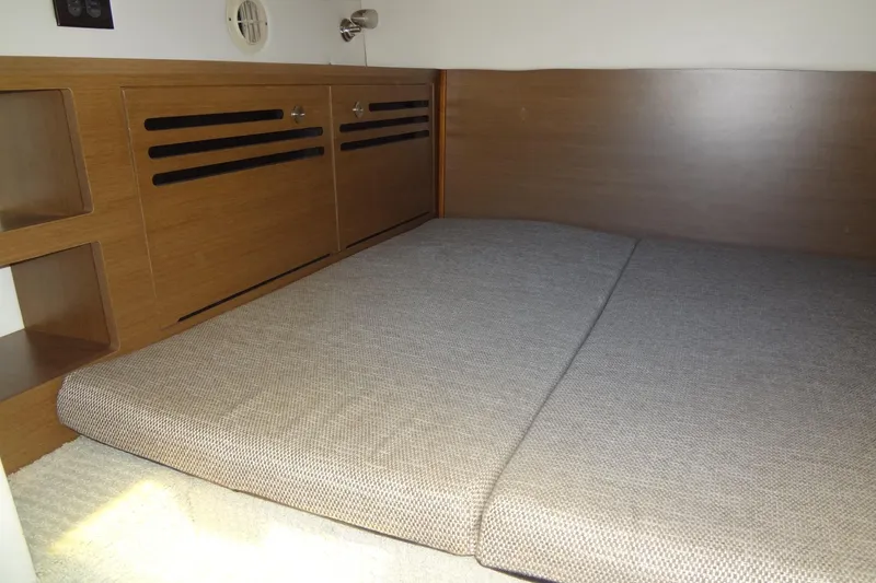 Slide: The Image of 2017 Sea Ray Sundancer 280 cabin interior with wooden paneling and cushioned seating. - 36