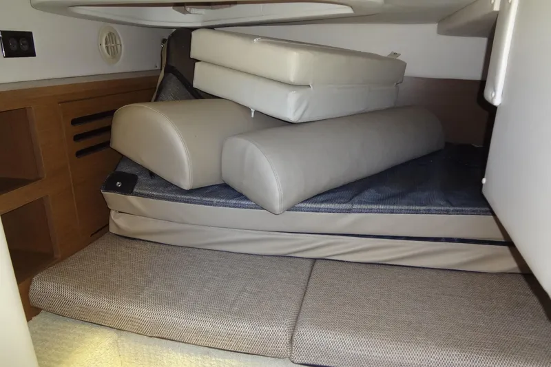 Slide: The Image of Interior cabin of 2017 Sea Ray Sundancer 280 with stacked cushions and wooden cabinetry. - 37