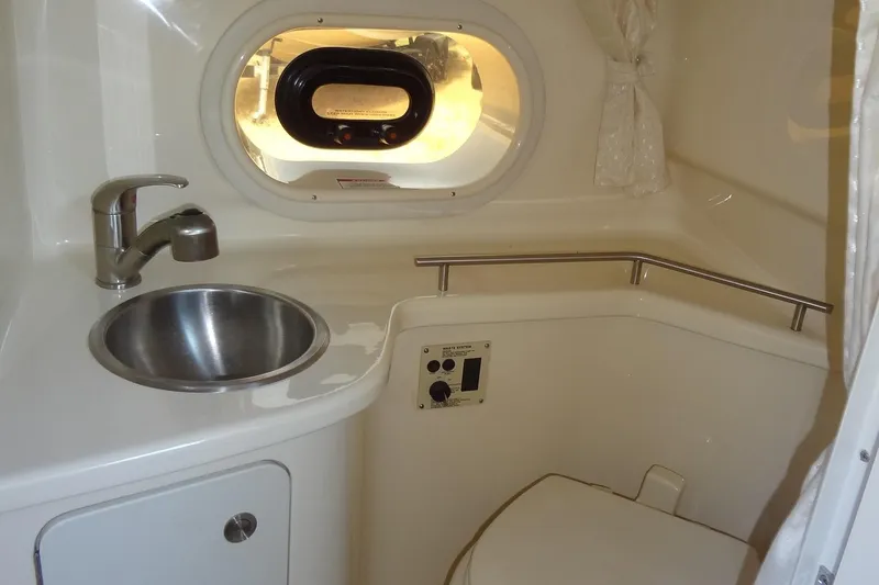 Slide: The Image of Interior of 2017 Sea Ray Sundancer 280 bathroom with sink, toilet, and porthole window. - 38