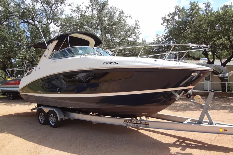 Slide: The Image of 2017 Sea Ray Sundancer 280 boat on trailer, parked outdoors under trees. - 6