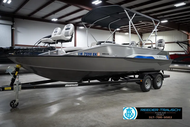 Slide: The Image of A Lowe boat on a trailer in an indoor showroom, featuring a canopy and seating. - 2