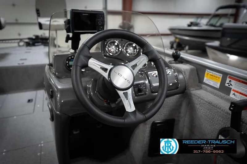 Slide: The Image of Steering wheel and dashboard of a 2022 Flowers SD224 boat, featuring modern controls. - 32