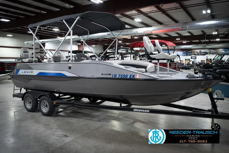 Slide: The Image of Pontoon boat on trailer in showroom, featuring canopy and seating, by Reeder-Trausch Marine. - 4