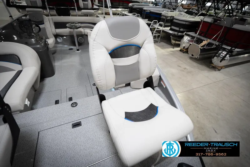 Slide: The Image of Pontoon boat interior with gray seating, showroom display, Reeder-Trausch Marine logo visible. - 47