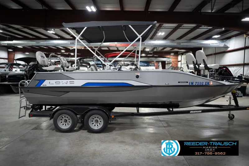 Slide: The Image of Boat on trailer in indoor showroom, featuring Lowe branding and Reeder-Trausch Marine contact details. - 5