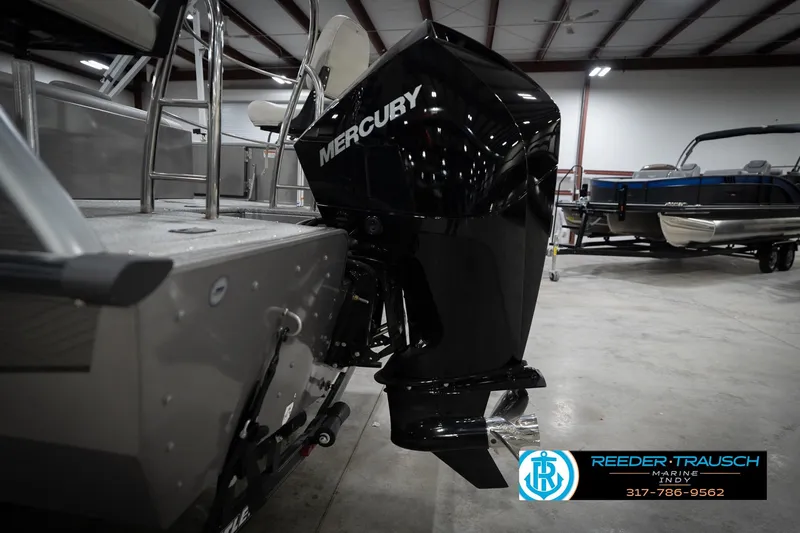 Slide: The Image of Boat with Mercury outboard motor in a showroom, featuring Reeder-Trausch Marine branding. - 53