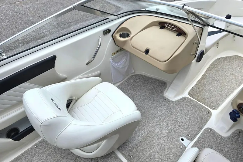 Slide: The Image of 2008 Glastron GT205 BR boat interior with white seating and beige dashboard. - 3