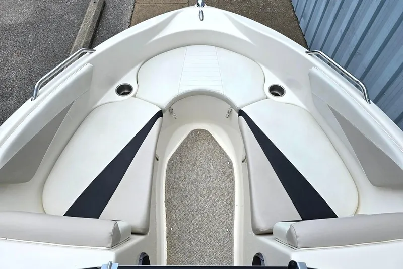 Slide: The Image of 2008 Glastron GT205 BR boat interior with white and black seating, cup holders, and carpeted floor. - 6