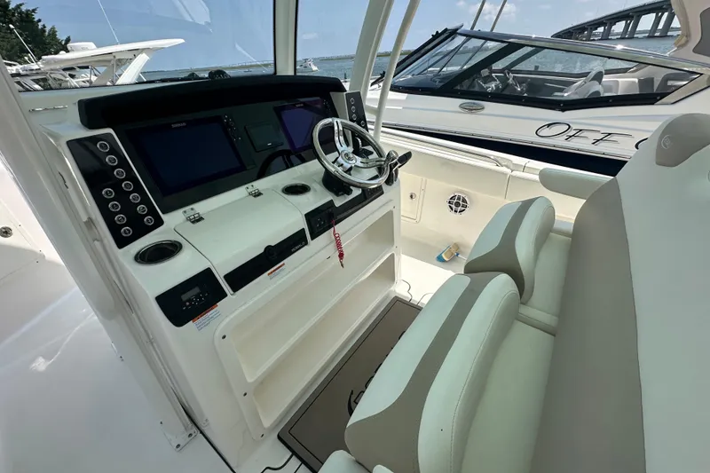 Slide: The Image of 2023 Robalo R302 Center Console boat interior with modern dashboard and seating. - 11