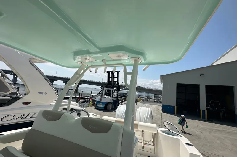 Slide: The Image of 2023 Robalo R302 Center Console boat at a marina with a forklift in the background. - 15