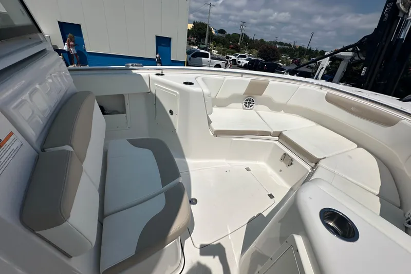 Slide: The Image of 2023 Robalo R302 Center Console boat interior with cushioned seating and cup holders. - 16