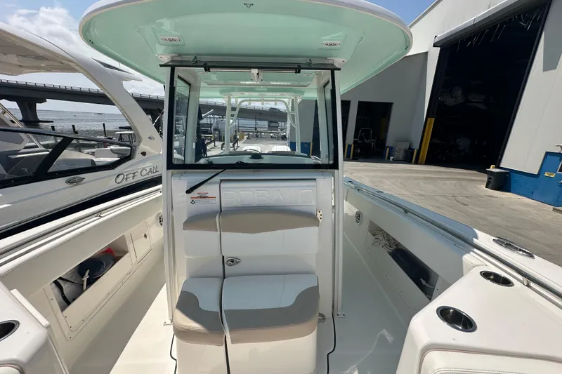 Slide: The Image of 2023 Robalo R302 Center Console boat docked at marina, showcasing interior seating and helm. - 19