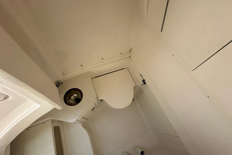 Slide: The Image of 2023 Robalo R302 Center Console boat interior with compact bathroom amenities. - 21