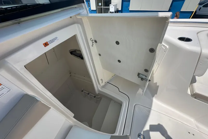 Slide: The Image of 2023 Robalo R302 Center Console storage compartment with open hatch, showcasing interior space. - 22