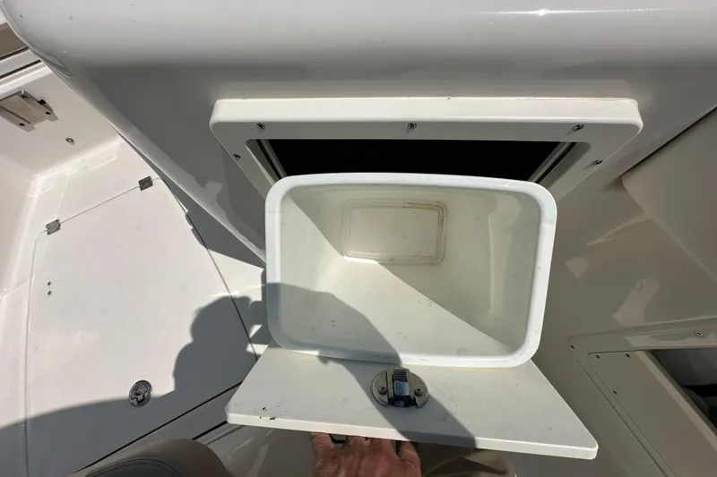 Slide: The Image of 2023 Robalo R302 Center Console storage compartment with open hatch. - 26
