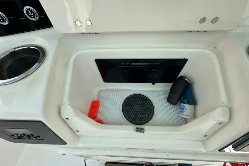 Slide: The Image of 2023 Robalo R302 Center Console storage compartment with 12V outlet and accessories. - 27